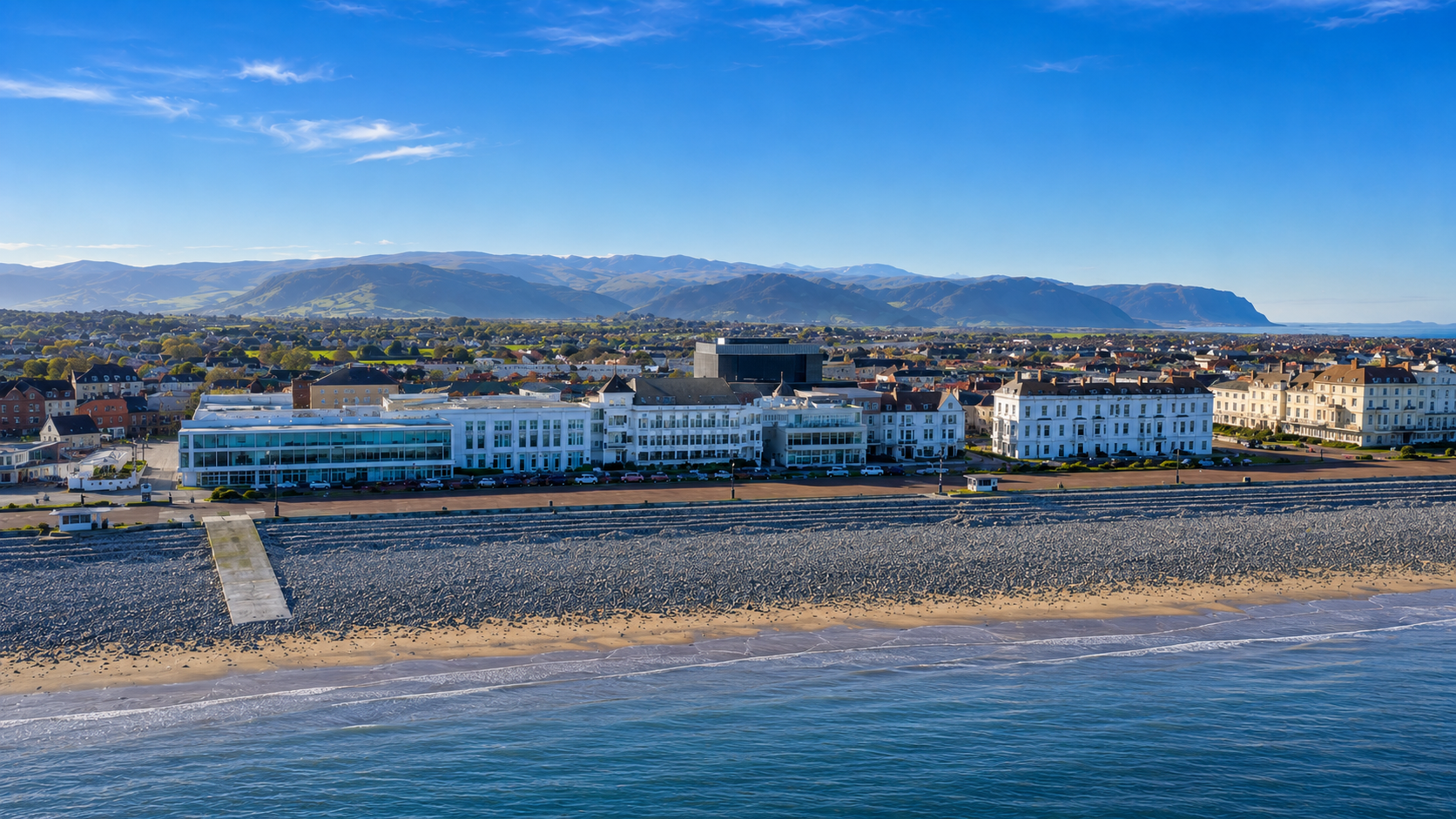 Aerial view of Venue Cymru on the Llandudno promenade, with the Snowdonia mountains behind